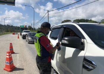 SIK Choon Foo memeriksa dokumen perjalanan yang dikemukakan pengguna jalan raya di SJR Kampung Tanah Putih, Gua Musang, Kelantan hari ini. - UTUSAN/AIMUNI TUAN LAH
