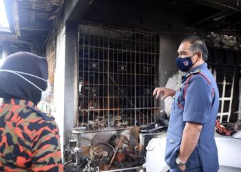 MD Ali Ismail (kanan) semasa melawat rumah mangsa di Taman Hungab, Penampang.-IHSAN Bernama