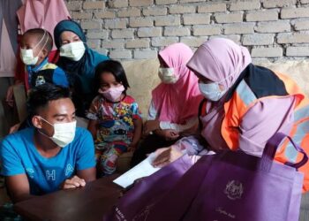 SITI Zailah Mohd Yusoff (kanan) menyantuni sebuah keluarga yang kehilangan ketua keluarga akibat nahas jalan raya di Dabong, Kuala Krai hari ini.