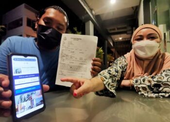 NURSUHAIDA Zainal Abidin dan suaminya, Erizan Abd. Latiff menunjukkan laporan polis dan tempahan penginapan yang dibuat mereka menerusi sebuah laman web tempahan penginapan pelancongan terkenal ketika ditemui di Port Dickson, semalam.-UTUSAN/MOHD. SHAHJEHAN MAAMIN.