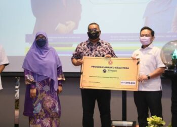 MUHAMMAD Sanusi Md. Nor (tengah) menyerahkan replika cek Program Anakku Sejahtera sebanyak RM1 juta kepada Wan Saiful Wan Jan pada Majlis Pelancaran Program Anakku Sejahtera di Aloft Langkawi di Pulau Tengah, Langkawi hari ini. - UTUSAN/NUR AMALINA AZMAN
