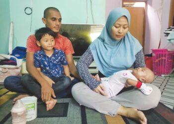 NOOR Diana Shaidon (kanan) memantau keadaan Muhammad Adha Mihakel sambik diperhati ahli keluarga lain di rumah mereka di Jalan Lubok, Tanah Merah, Kelantan. - UTUSAN/ROSALWANI CHE SOH