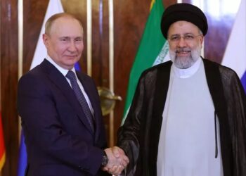 PRESIDEN Russia, Vladimir Putin (kiri) berjabat tangan dengan Presiden Iran, Ebrahim Raisi dalam satu pertemuan di Teheran Julai lalu.-AGENSI 