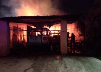 ANGGOTA bomba berusaha memadamkan api yang melibatkan sebuah rumah jenis kekal setingkat di lokasi kejadian di Kampung Padang Kerbau, Miri.