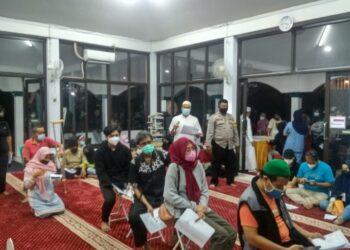 ORANG ramai menunggu giliran untuk menerima suntikan dos penggalak vaksin Covid-19 di masjid selepas menunaikan solat tarawih. - AGENSI