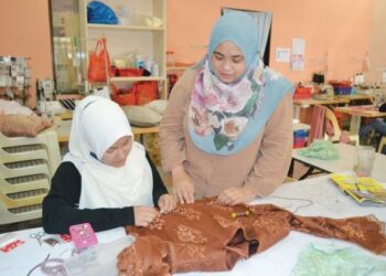 NURZAYANI Zaharudin bersama pekerjanya menyiapkan tempahan pakaian pelanggan untuk digayakan sempena rumah terbuka Hari Raya Aidilfitri tahun ini. – UTUSAN/ZAKKINA WATI AHMAD TARMIZI