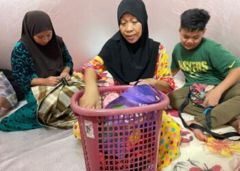 MARHUMAH Arifin (tengah) bersama anaknya, Wahyuni Mohd. Zaidi ketika ditemui di PPS Dewan Selagon, Beaufort hari ini.