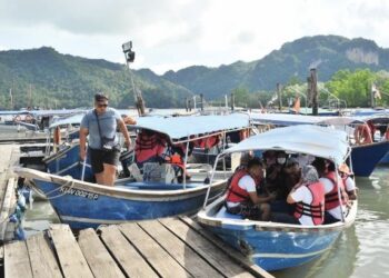 DERETAN bot pelancongan yang membawa pelancong menyusuri kawasan paya bakau di Kilim Karst Geoforest Park, Langkawi. –  UTUSAN/SHAHRIL AZMAN