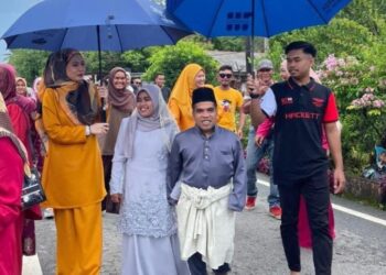 MOHD. Iriman Zakaria dan isteri, Nurul Ziana Yusoff sewaktu majlis sambut menantu di Felda Jerangau Barat, Hulu Terengganu, Sabtu lalu.