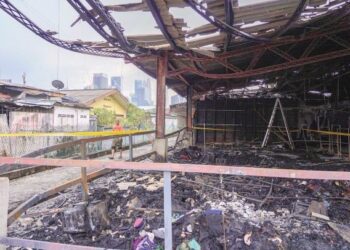PENDUDUK melihat kawasan Pasar Keramat yang terbakar yang turut melibatkan sebahagian kawasan rumah berhampiran. – MINGGUAN/FARIZ RUSADIO