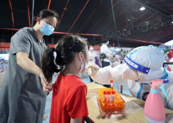 PETUGAS kesihatan melakukan ujian calitan mengesan Covid-19 di Xiamen, wilayah Fujian, timur China. - AFP  