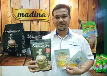 MUHAMMAD Rizal Osman menunjukkan produk buah-buahan kering dan produk minuman kopi dihasilkan syarikatnya. - UTUSAN/MOHD HUSNI MOHD NOOR