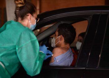 SEORANG penduduk menerima suntikan vaksin Covid-19 secara pandu lalu di sebuah pusat pemberian vaksin di stadium Nuevo Colombina di Huelva, Sepanyol. - AFP