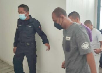 TERTUDUH (baju kelabu) dibawa anggota polis semasa menghadiri perbicaraan di Mahkamah Tinggi, Kota Bharu, Kelantan. - UTUSAN/ROSALWANI CHE SOH