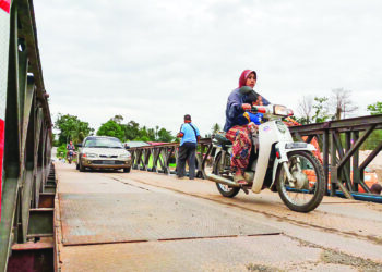 PENDUDUK kembali menggunakan Jambatan Bailey yang siap dibaiki selepas rosak akibat banjir kali ketiga di Kampung Iboi, Kupang di Baling. - UTUSAN/NORLIA RAMLI