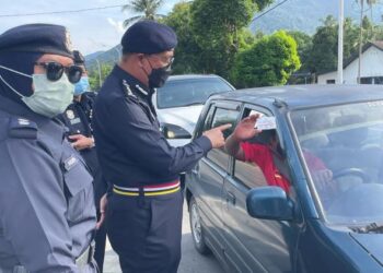 SHAFIEN Mamat melakukan pemeriksaan rawak terhadap sijil digital vaksin pemandu yang melalui SJR Bukit Yong, Pasir Puteh, petang ini. - UTUSAN/ TOREK SULONG
