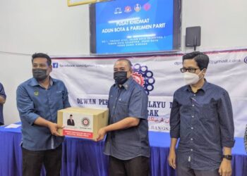 KAMARULLAFFIE Ahmad (tengah) menyampaikan sumbangan kotak makanan kepada Khairul Shahril Mohamed di Bota dekat Parit hari ini. - UTUSAN/ MOHAMAD HAFIZI MOHD. SAID