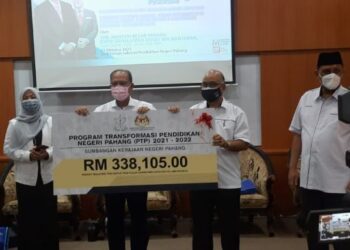 WAN ROSDY Wan Ismail (tengah) menyampaikan replika cek program Transformasi Pendidikan Pahang (TPP) kepada Pengarah Pendidikan negeri, Rosli Abdul Rahman (dua, kanan) di Auditorium Jabatan Pendidikan Negeri Pahang (JPNP)  di Kuantan, Pahang. - FOTO/DIANA SURYA ABD WAHAB