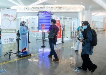 KAKITANGAN Malaysia Airport memeriksa tiket para penumpang sebelum menaiki pesawat penerbangan ketika tinjauan orang ramai kebenaran rentas negeri di KLIA 2, Sepang, Selangor. - UTUSAN/FAISOL MUSTAFA