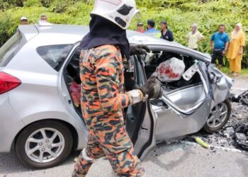 ANGGOTA bomba mengeluarkan mangsa yang tersepit dalam kereta dalam kemalangan di Kilometer 34, Jalan Simpang Pulai- Cameron Highland, Ipoh hari ini.  - UTUSAN/IHSAN JBP