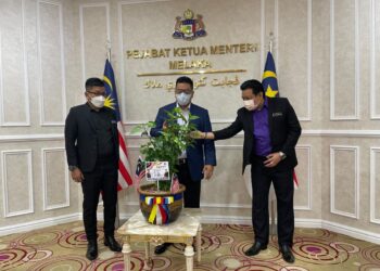 MUHAMMAD MUHAIMIN LAU Abdullah (kanan) menunjukkan bunga raya unik empat warna kepada Sulaiman Md. Ali (tengah) sambil disaksikan Pengerusi Jawatankuasa Pertanian, Penternakan, Pembangunan Usahawan dan Koperasi negeri, Datuk Norhizam Hassan Baktee di Seri Negeri, Ayer Keroh, Melaka. - UTUSAN/DIYANATUL ATIQAH ZAKARYA
