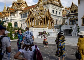 PELANCONG asing bergambar di luar pekarangan Istana Besar di Bangkok. - AFP  