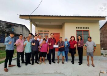 NGEH Koo Ham (enam dari kanan) bersama Lau Choon Hu (lima dari kanan) bergambar di depan rumah baharu bantuan kerajaan di Pekan Gurney, Sitiawan, Perak.
