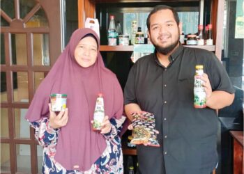 MUHAMMAD Zafiq Fitri Zubir bersama ibunya, Siti Aishah Ishak menunjukkan produk yang dihasilkan oleh Syarikat Onlyone Zuza Food Industries di Pekan Napoh, Kubang Pasu.