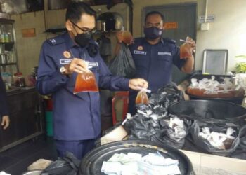 Sheikh Hakimin Hassan (kiri) menunjukkan sebahagian makanan dan minuman yang siap dibungkus untuk dijual kepada pelanggan pada Ops Plastik Hitam di sebuah premis di Taman Gurun Jaya,  Gurun, Sungai Petani hari ini. - UTUSAN/OTHMAN YAHAYA