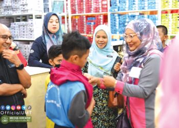 SALAH seorang pelajar dibantu ahli Mutiara UMT mencuba pakaian baharu dalam program Kasih Ramadan 2023 di Kuala Nerus, Terengganu, baru-baru ini.