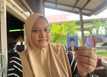 NURHAYATUL Husna Abdul Muttalib menunjukkan gambar Koperal Mohammad Nasri Mohd. Nasib di rumah ibu mentuanya di Pulau Mertajam, Penaga, Pulau Pinang. - Pix: SITI NUR MAS ERAH AMRAN