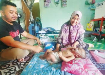NORAIN Wahab dan suaminya, Mohd. Firdaus Abu Seman bersama anak mereka, Muhammad Umar Harith yang menghidap masalah penyakit jantung ketika ditemui di rumah mereka di Kampung Keda Bagan Sena di Labu Besar, Kulim. -UTUSAN/AZAHAR HASHIM