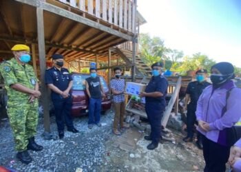 YUSUH Mat Tais (tiga kanan) menyampaikan bantuan bakul makanan kepada  seorang penerima dalam Program Op Bantu Ibu Pejabat Polis Daerah (IPD) Kota Kinabalu hari ini. Turut kelihatan Ketua Polis Daerah Kota Kinabalu, Asisten Komisioner Mohd. Zaidi Abdullah (dua kiri).