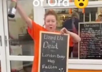 JAKI Pickett memegang papan tulis yang tertera ‘Lizard Liz is dead’' dengan sebotol champagne. - AGENSI