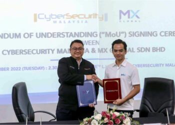 AMIRUDIN Abdul Wahab (kiri) dan Fadzli Shah Anuar bertukar dokumen perjanjian persefahaman (MoU) di Cyberjaya, hari ini. - UTUSAN/FAISOL MUSTAFA