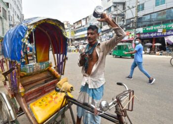SEORANG penarik beca menuang air ke atas kepala ketika cuaca panas di Dhaka, Bangladesh.-AGENSI