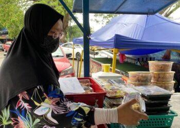AIEDHAH Nurfajrina Abd. Latip menyusun produknya di kedai milik kenalannya di Temerloh, Pahang.  – UTUSAN/NORHAFIZAN ZULKIFLI