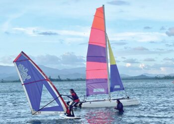 DUA sahabat baik, Sharifah Nadiah Wafa Syed Mohd Thalal Wafa dan Siti Nursarah Salehhodin menawarkan aktiviti katamaran yang pertama di tasik di Tasik Timah Tasoh, Padang Besar, Perlis. – UTUSAN/ASYRAF MUHAMMAD