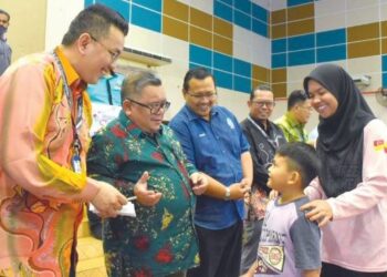 ZAIDI Attan (dua dari kiri) beramah mesra dengan seorang penerima pada program Back To School 2023 di Dewan MPJ, Lipat Kajang, Melaka. – FOTO/MUHAMMAD SHAHIZAM TAZALI