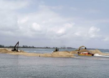 KERJA-KERJA mendalamkan laluan bot sedang dilaksanakan di muara Sungai Merang, Setiu, Terengganu. - UTUSAN/KAMALIZA KAMARUDDIN