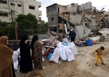 PENDUDUK menyelamatkan harta benda di sebuah bangunan kediaman yang musnah akibat serangan udara Israel di Gaza. - AFP