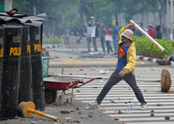 PENUNJUK perasaan cuba memukul anggota keselamatan dalam proses bantahan Undang-Undang Cipta Kerja di Jakarta, Indonesia. -AFP