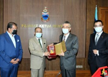 HAJIJI Noor (dua kiri) menerima cenderamata daripada Chou Chun Chi (dua kanan) semasa kunjungan hormat di Menara Kinabalu di Kota Kinabalu semalam.-IHSAN Jabatan Ketua Menteri