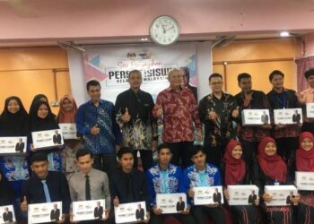 ANNUAR Musa (tengah) bergambar bersama sebahagian penerima peranti siswa pada Sesi Penyerahan Peranti Siswa Keluarga Malaysia di Sekolah Menengah Kebangsaan (SMK) Melor, Kelantan, hari ini. UTUSAN/ ROSMIZAN RESDI