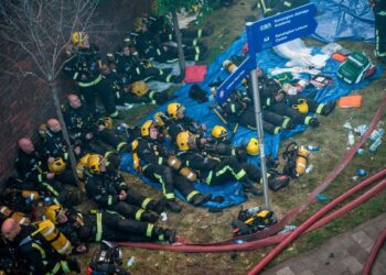ANGGOTA bomba yang dikerahkan memadam kebakaran Menara Grenfell berehat berhampiran lokasi kejadian.-AGENSI