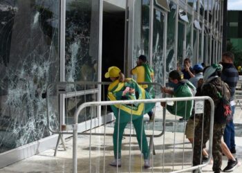 PENYOKONG Bolsonaro memecahkan tingkap bangunan Mahkamah Agung ketika rusuhan pada Ahad lalu di Brasilia. - AFP 