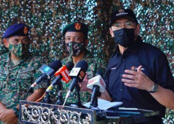HISHAMMUDDIN Hussein (kanan) semasa sidang akhbar di Kem Kukusan, Tawau hari ini.
