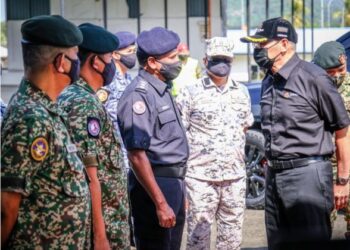 KEHADIRAN Hishammuddin Hussein (kanan) disambut oleh pegawai kanan Markas ATB 2, Kem Kukusan di Tawau hari ini.