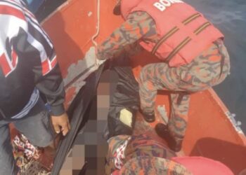 Pasukan bomba membawa mayat mangsa bot karam di perairan Pulau Tagabua, Kunak hari ini.-IHSAN BOMBA