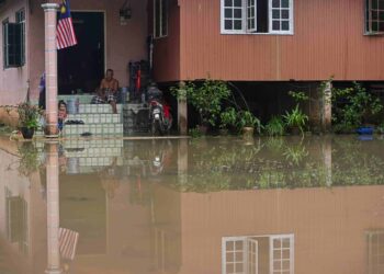 SEORANG penduduk melihat keadaan rumahnya yang ditenggelami banjir di Kampung Nibong, Hulu Terengganu baru-baru ini. – MINGGUAN/PUQTRA HAIRRY